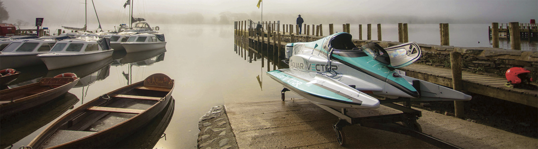 Jaguar Vector electric record boat on a misty Coniston jetty beside moored boats before its speed run