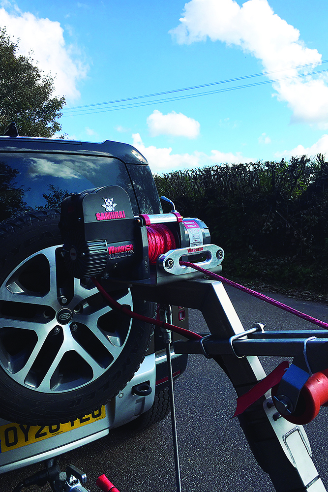 Electric trailer winch mounted on Vanclaes boat trailer, connected to Land Rover Defender for boat recovery and loading.