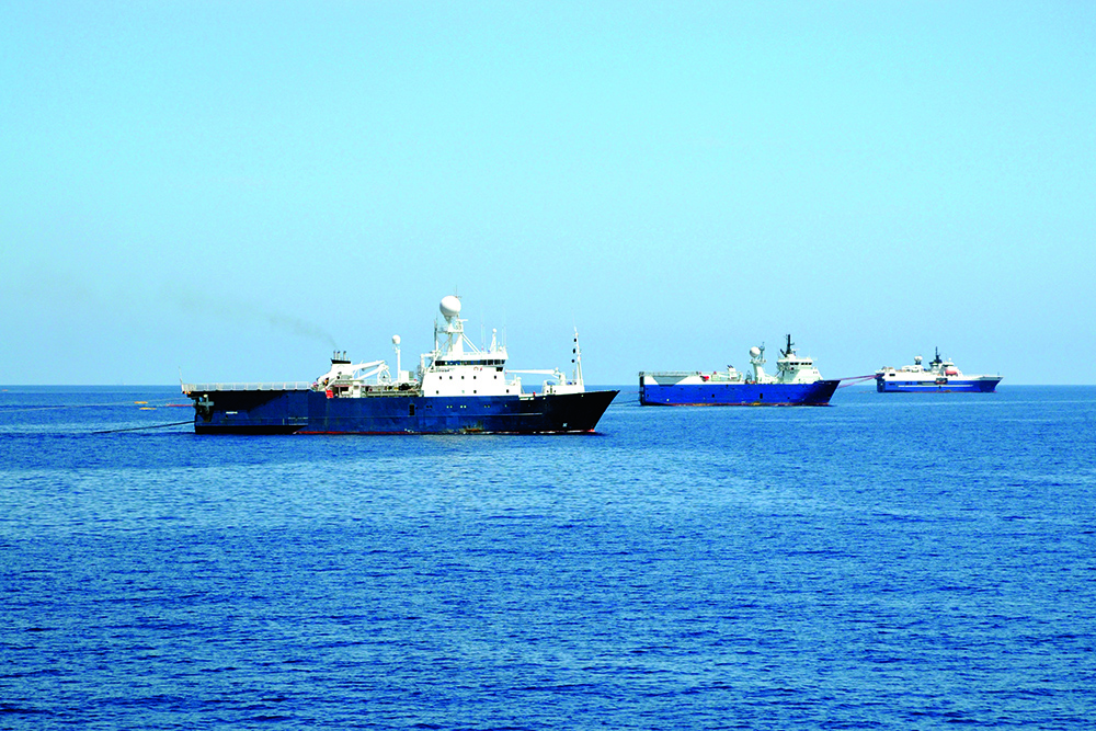 Multiple survey and industrial vessels at sea, highlighting seismic activity and shipping noise affecting marine ecosystems