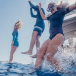girls jumping into the sea