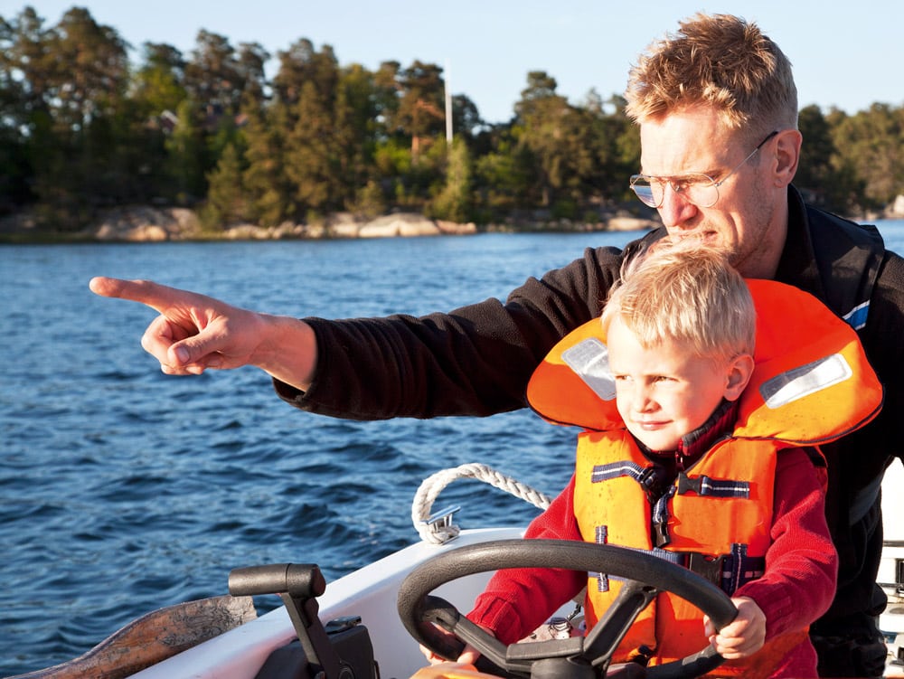 Father and son steering small boat in Stockholm Archipelago © Britta Kasholm-Tengve -iStockphoto