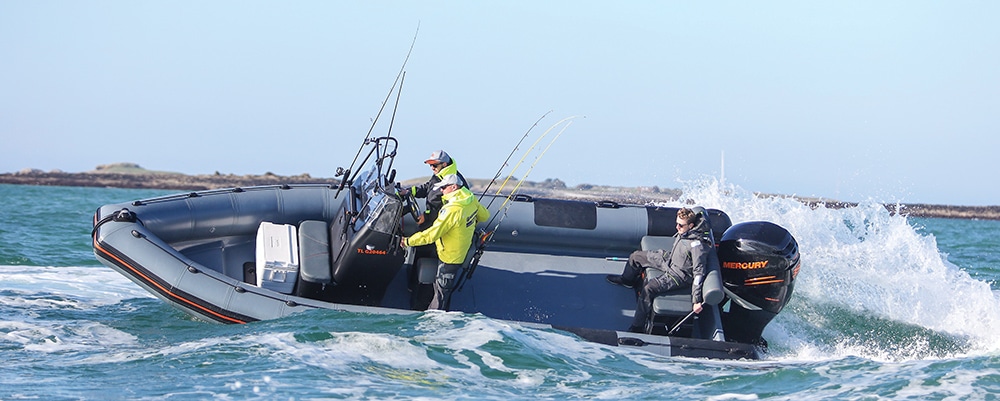 Grey RIB underway with fishing rods and 3 people onboard