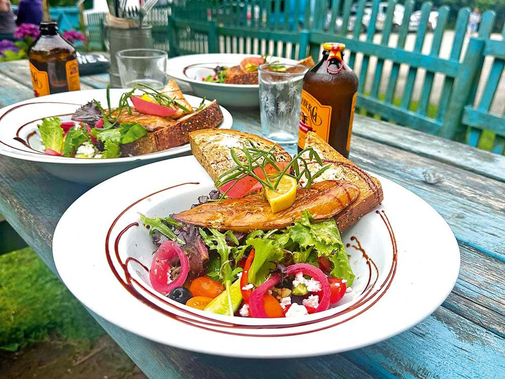 A fresh smokie salad served outdoors on a rustic table.