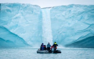 Arctic Expedition Micro Cruises from Secret Atlas. Zodiac in front_ of a waterfall Brasvellbreen Svalbard