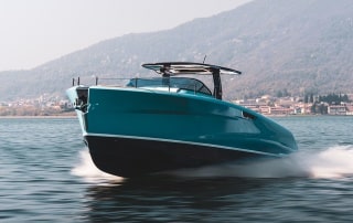 Astor 36 voyaging across the water with land in the background.