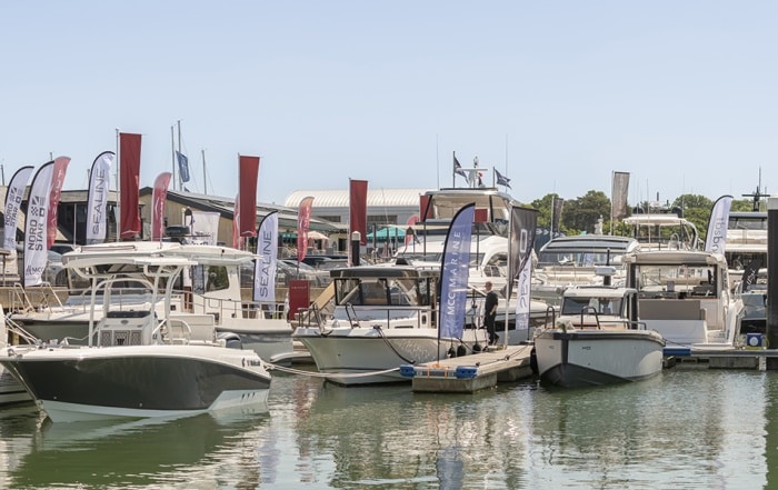 Motor yachts and powerboats docked at Swanwick Marina during the 2025 British Motor Yacht Show, with branded flags and clear skies.