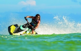 Man with muscles and longer hair riding a turn on a Yamaha JetBlaster Pro jet ski