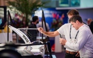 Two men examine a marine product display at Metstrade.