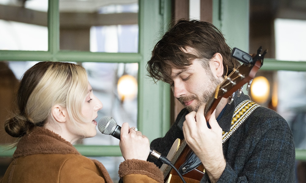 Young man playing guitar and a young woman singing
