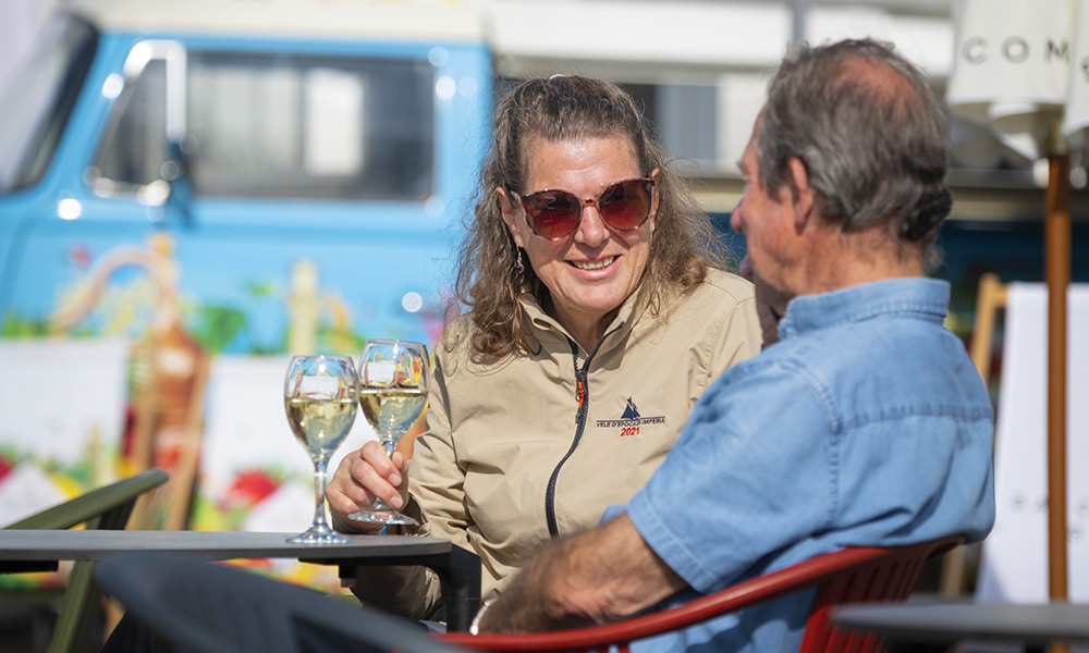 Man and woman sat at a table drinking glasses of white wine
