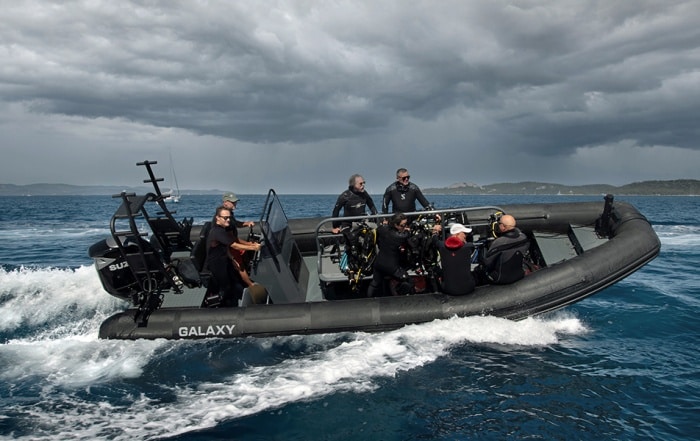 Galaxy RIB with dive crew and equipment underway at speed in open water.