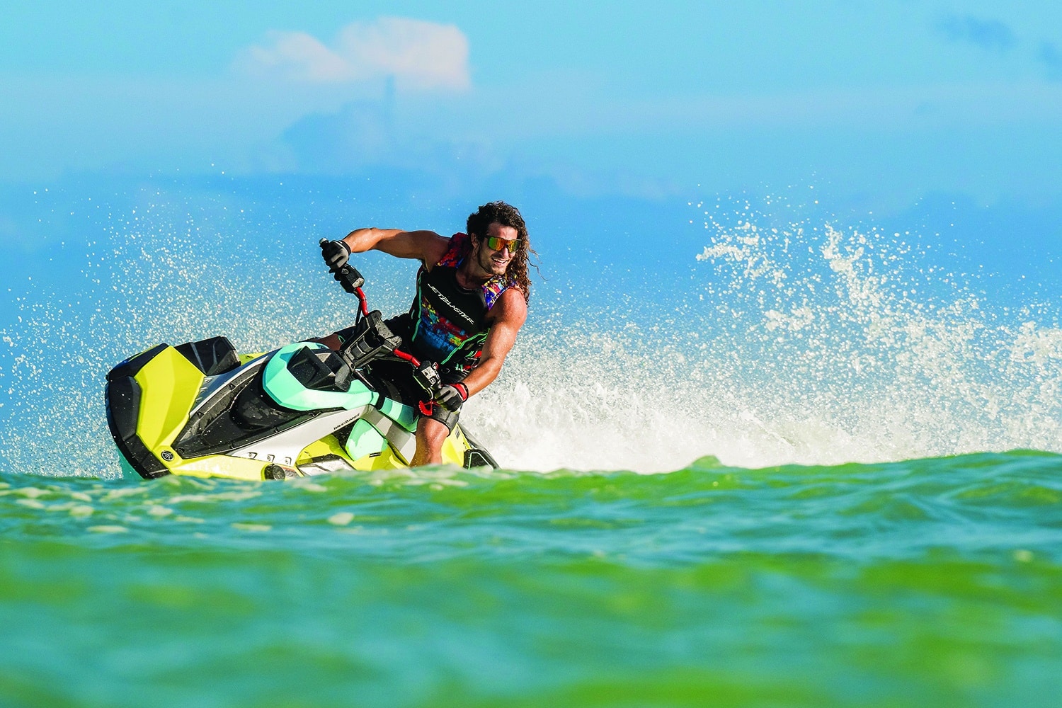 Man with muscles and longer hair riding a turn on a Yamaha JetBlaster Pro jet ski