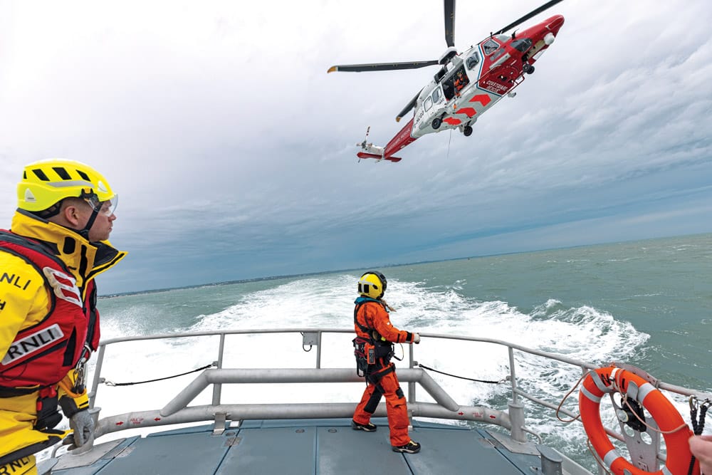 RNLI Relief Tamar class lifeboat Edward and Barbara Prigmore 16-10 undertaking a training exercise with HM Coastguard helicopter for the RNLI working with helicopters film. Crew on deck wearing new Petzl helmets.