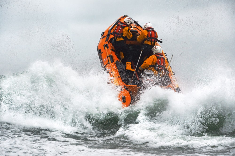 St Agnes D-class inshore lifeboat Blue Peter IV D-641 heading through a breaking wave. © Nigel Millard