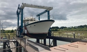 Large motor yacht being lifted from the water at Northney Marina by a 35-ton marine hoist.