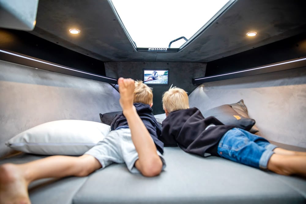 Ryds 650DC VI. Kids relaxing below, enjoying the flat-screen TV.