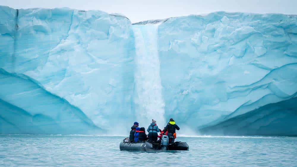 Arctic Expedition Micro Cruises from Secret Atlas. Zodiac in front_ of a waterfall Brasvellbreen Svalbard