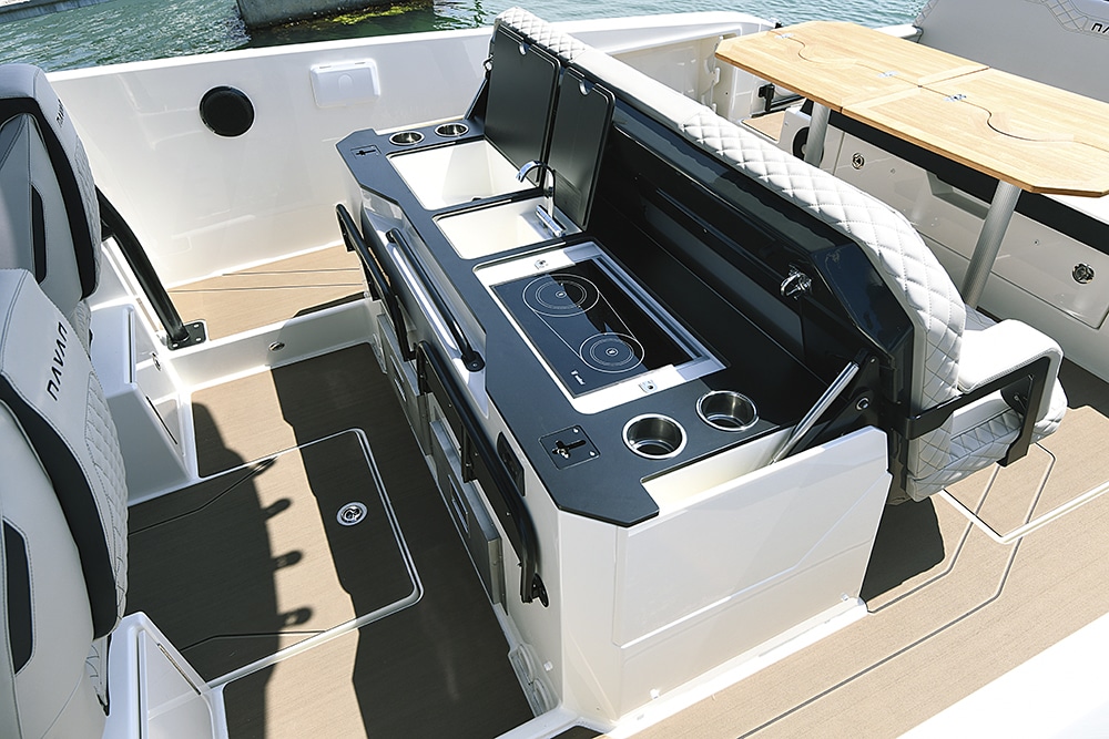 An image of a galley, with fridge, sink and hob onboard the Navan S30 boat.