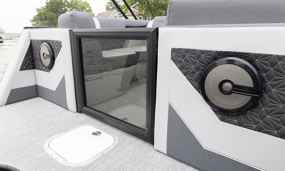 Alera Model M interior showing Roswell speakers, diamond-stitched panels, and a side access hatch with modern marine upholstery.