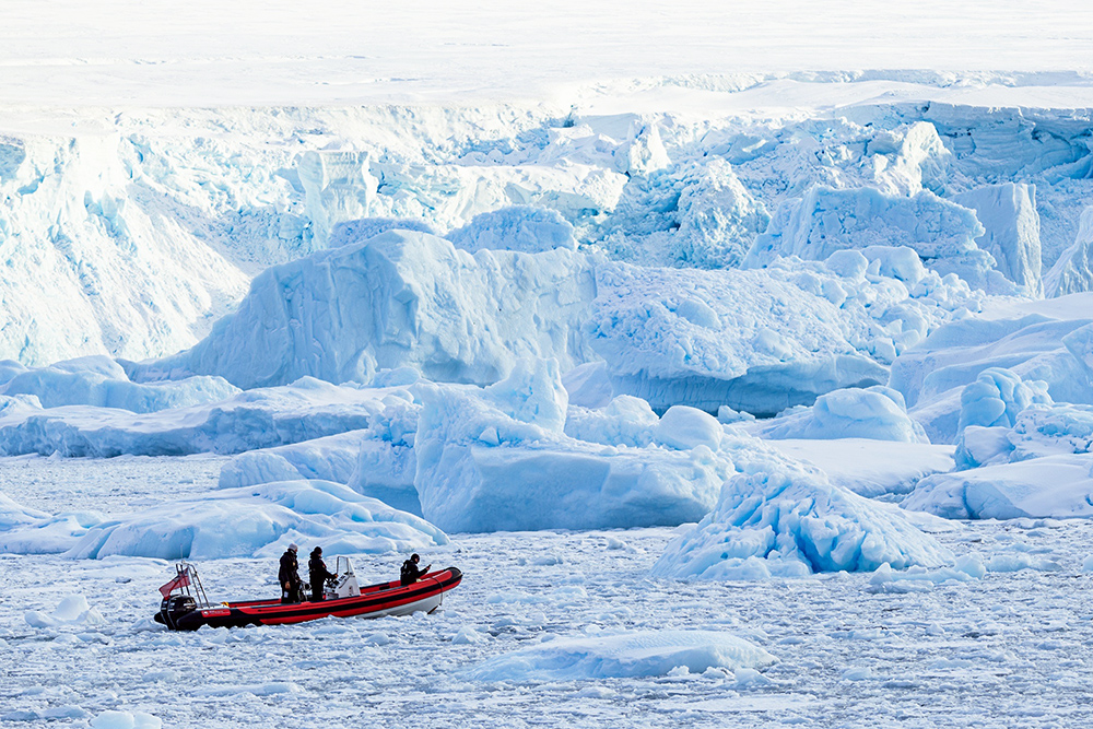 Red RIB in front of icebergs