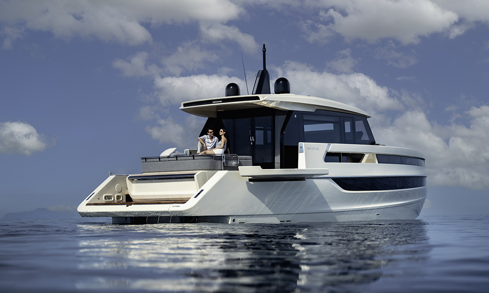 Couple relaxes on the aft lounge of the Invictus ST550 yacht, anchored in calm waters.