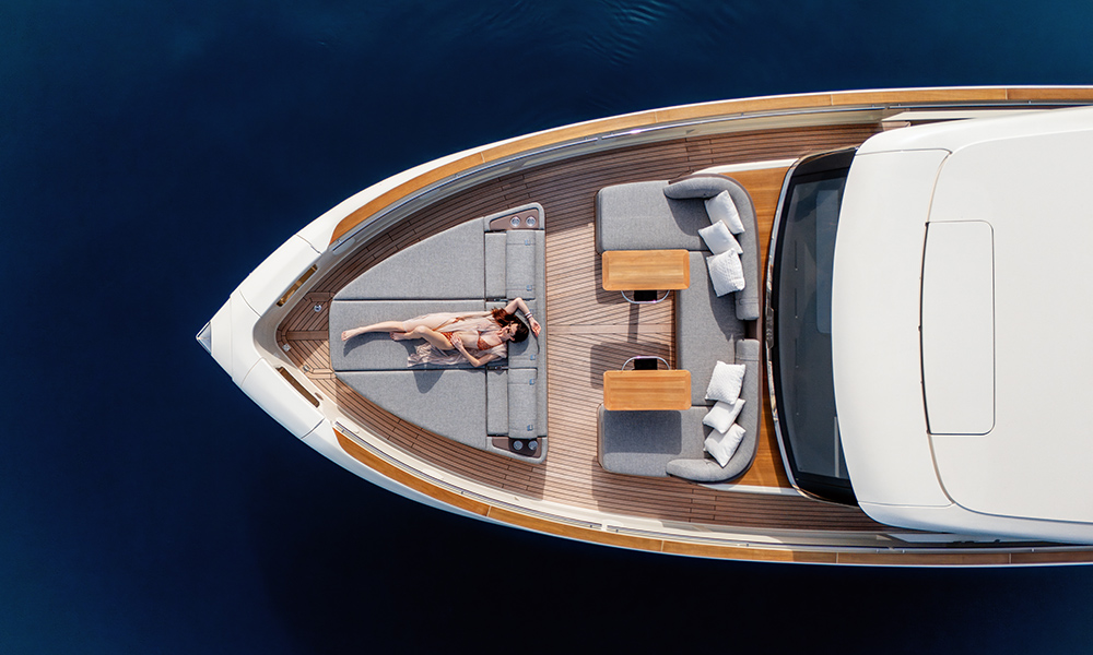 Woman sunbathes on foredeck loungers aboard Invictus ST550.