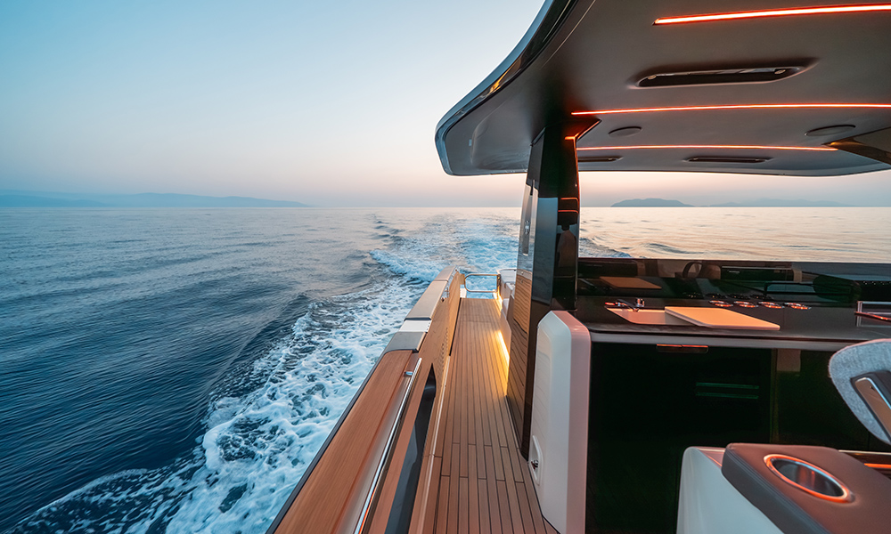 Invictus Yacht's TT550 starboard deck with teak flooring and ambient lighting.