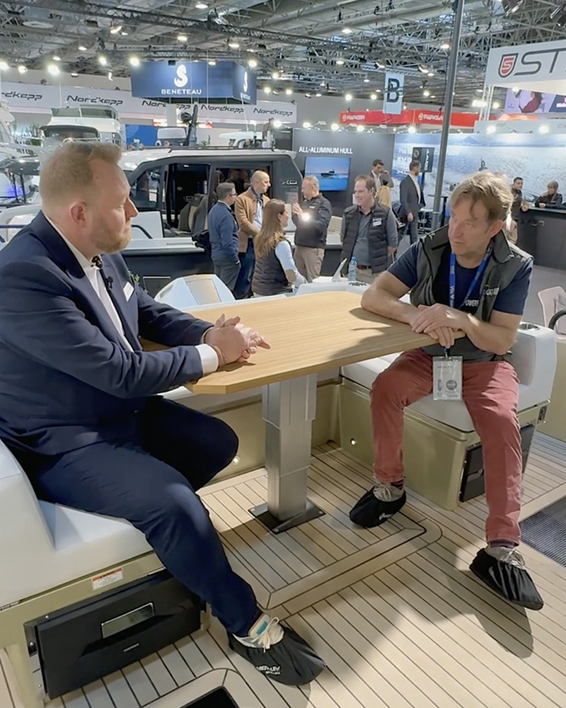 Steve Chambers and Hugo Montgomery-Swan sat on the aft deck lounge area of the XO EXPLR 44 at Boot Dusseldorf boat show