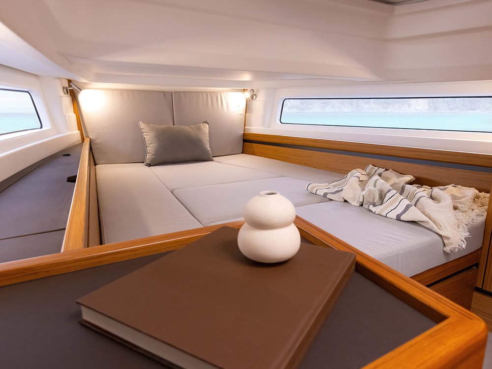 Modern cabin interior of Aiata Wayfinder 38 with side windows overlooking the water.
