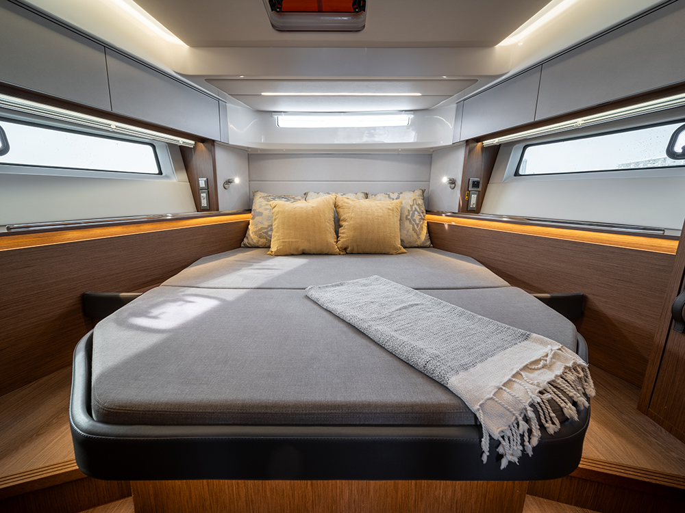 Owner's cabin aboard the Antares 12 Coupe, with bed, side windows, and integrated storage.