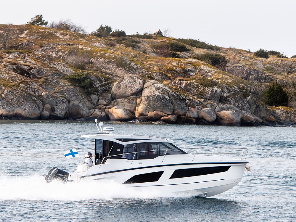 Grandezza 30 Outboard cruising past a rocky coastline.