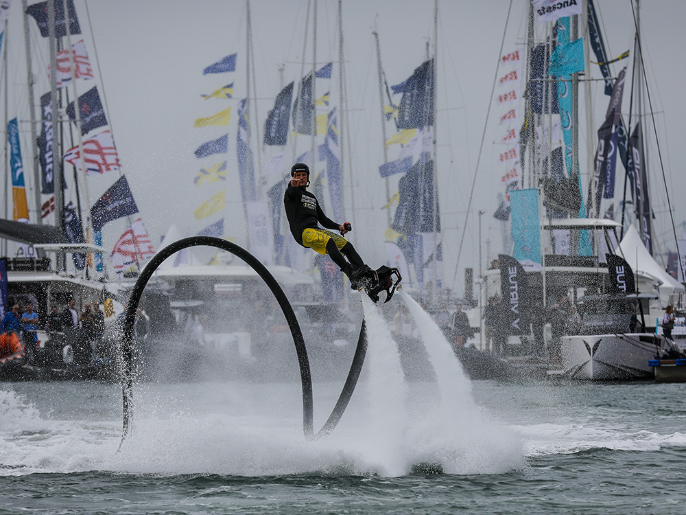 Flyboard performer soars above the water with powerful jets, entertaining crowds at Southampton International Boat Show.