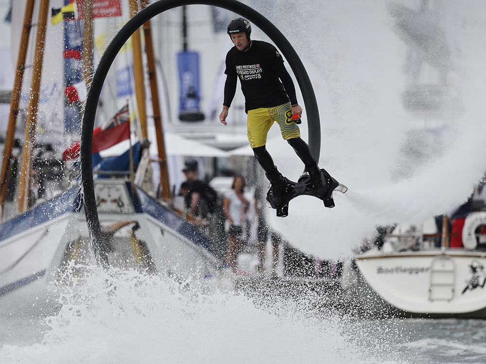 Flyboard stunt performer rises above the water on powerful jets during a live display at Southampton International Boat Show.