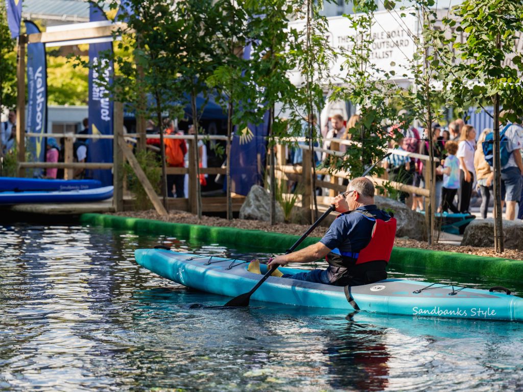 Man paddling a blue kayak at Southampton International Boat Show.