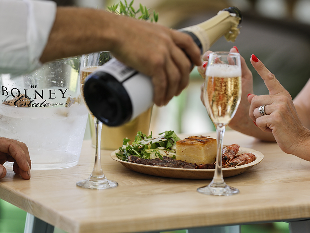 Champagne poured into glasses at restaurant table.