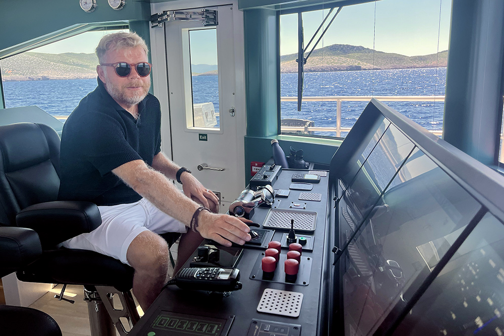 Man at helm of large boat
