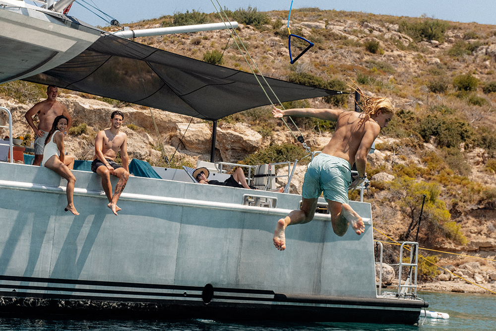 Two people jumping from a boat into the sea in Greece