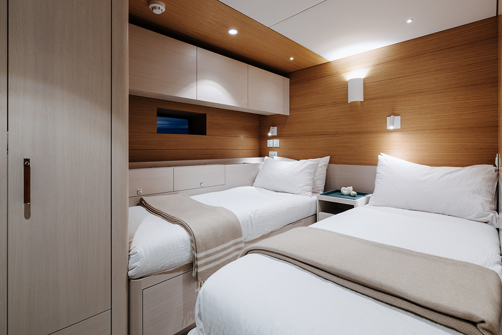 Lower deck twin cabin showing twin beds with white linen