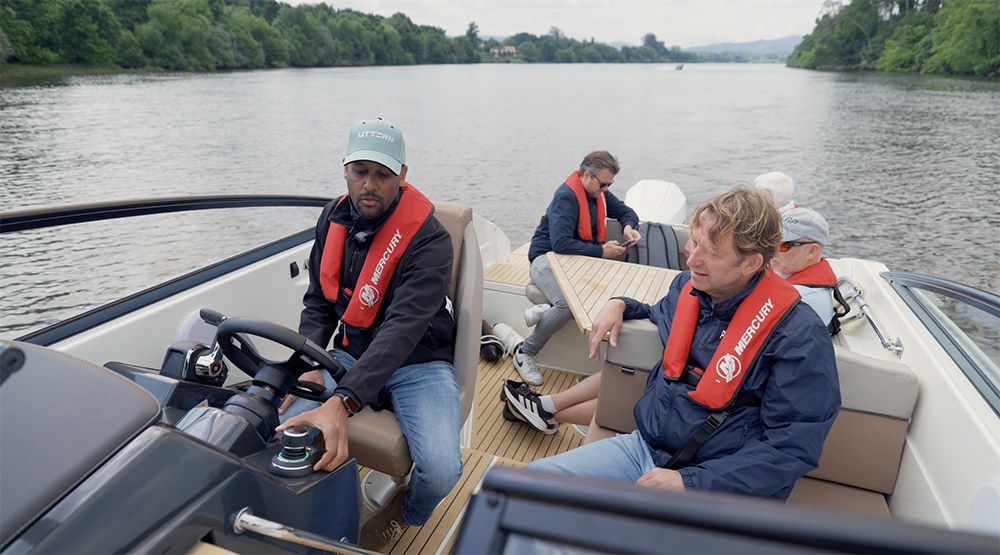 People sat onboard with helmsman showing how to use Mercury joystick