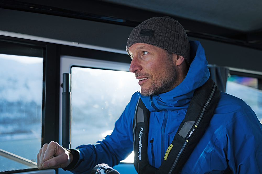 Aksel Lund Svindal - two-time Olympic champion - with blue coat and lifejacket driving a boat