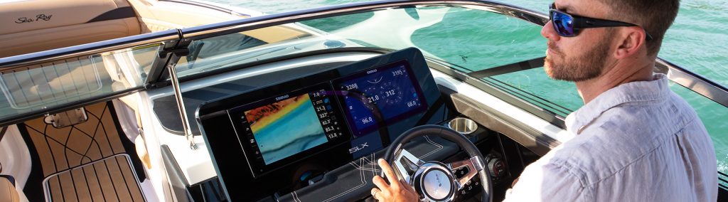 man at the helm of a SeaRay craft with Simrad electronics on the dash