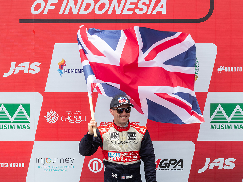 Ben Jelf celebrates on the podium at Lake Toba, proudly holding the Union Jack after securing double bronze in Indonesia.