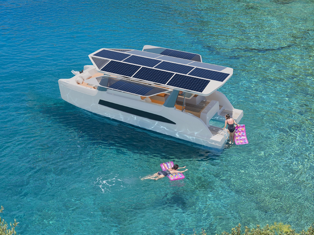 Solar-powered catamaran with roof-mounted panels anchored in clear blue.