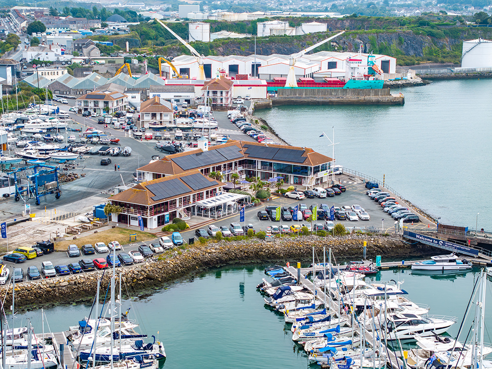 MDL marina with yachts, boatyard, and waterfront buildings.