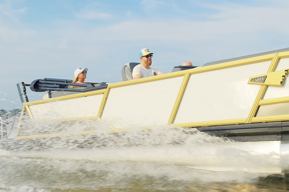 Alera M23 pontoon boat underway fast at sea in bright sunshine