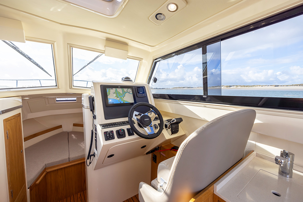 Orkney Pilothouse 27 helm station showing electronics and grey upholstery to chair