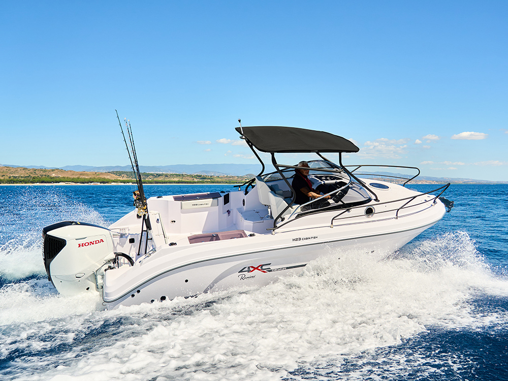 Honda 4XC powered by Honda outboard cruising off the coast under clear blue skies.