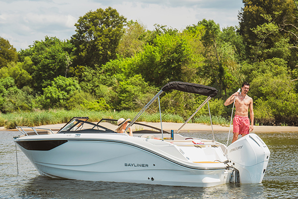 Bayliner C21 at acnhor with lady relaxing and man using aft shower hose to rinse off after a swim