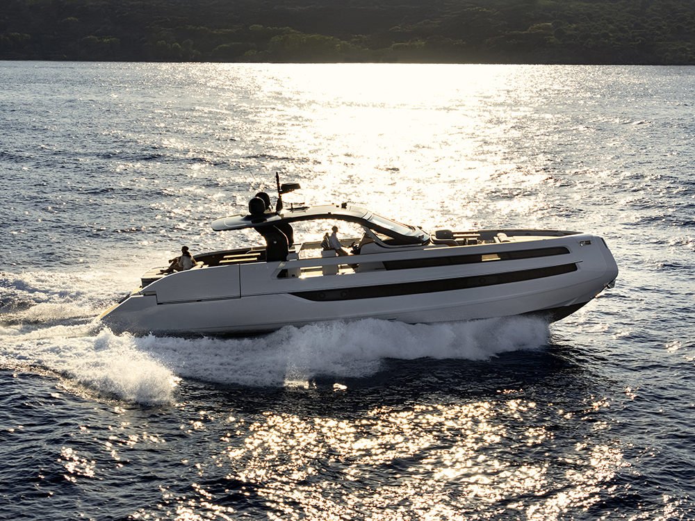 Invictus TT550 luxury yacht cruising at speed across sunlit water.