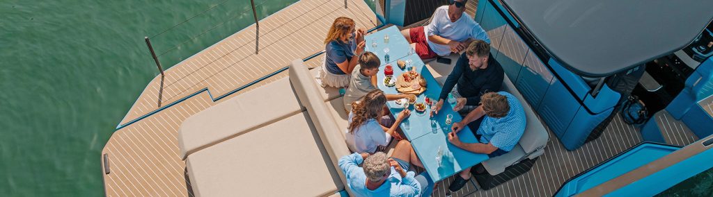 7 people sat around dining area eating lunch on Bellini Astor 36